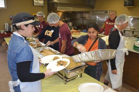 Volunteers at the 2014 dinner dish up turkey and stuffing.
